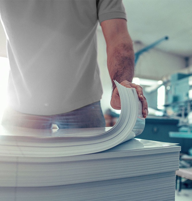 Office employee using ARC Document Solutions to organize stack of paper